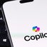 Copilot logo on phone screen on laptop keyboard