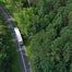 White truck on road through trees